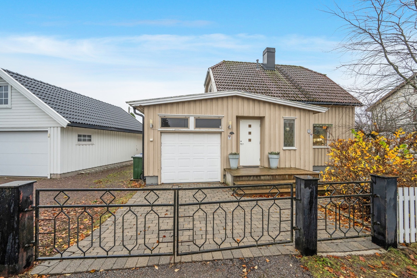 Tomten er inngjerdet med gjerde/hekk - vi fortsetter inn porten Galleribilde