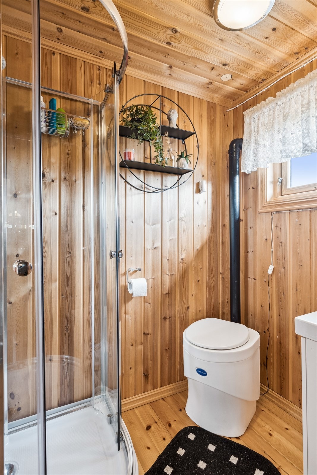 Enkelt hyttebad med servantskap, biodo og dusjkabinett. Opplegg vann til servant og dusj fra dunk/beholder med 12v pumpe. Galleribilde