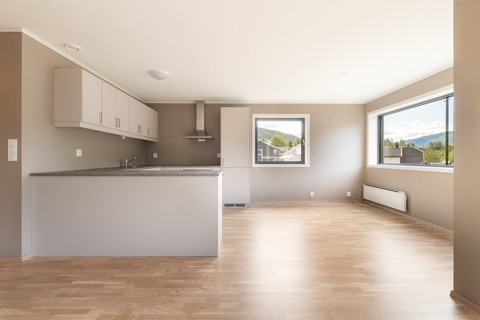 Kjøkkenet er romslig med stilren kjøkkeninnredning, integrerte hvitevarer og gode arbeidsflater. Halvøy skaper et godt skille til stuedelen. Galleribilde