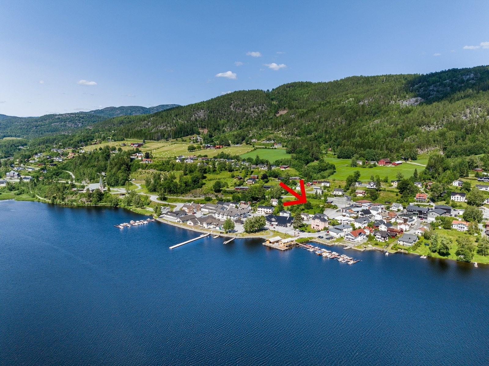Sentral beliggenhet midt i Kviteseid sentrum. Dronefoto med pil på eiendommen før utbyggingen startet. Galleribilde