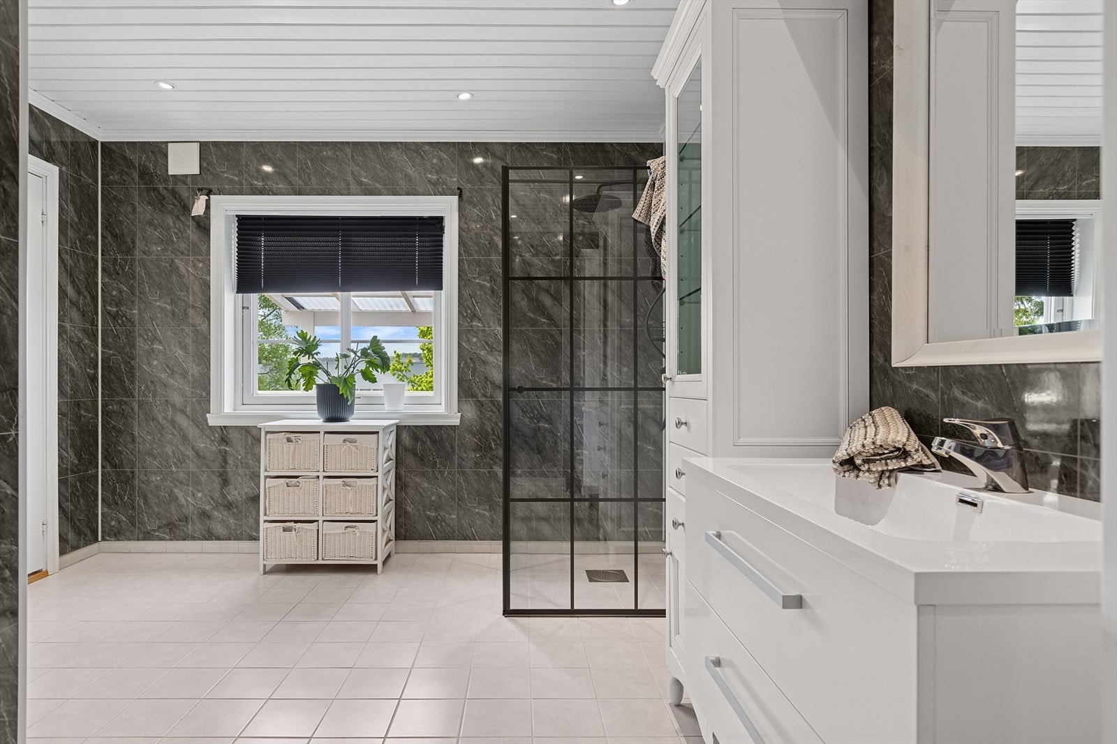 Badet er praktisk innredet med nedfelt servant, toalett og dusjhjørne med dusjvegger. Galleribilde