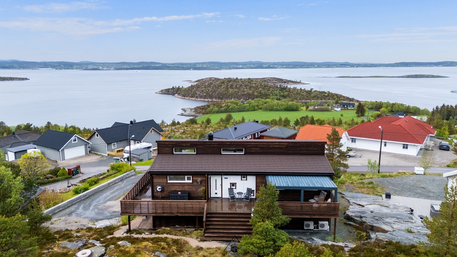 Uteområdet bak huset er pent opparbeidet med en romslig terrasse med pergola og trapp ned på tomta. På husveggen er det vannkran med både varmt og kaldt vann. Galleribilde