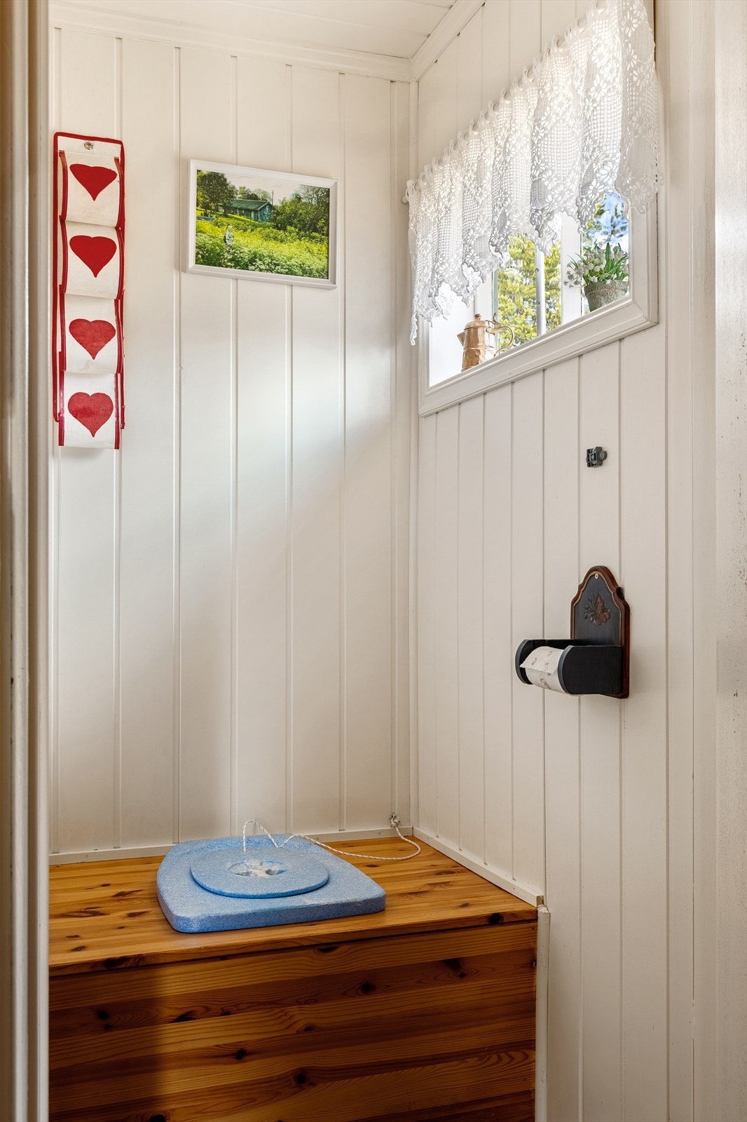 Utedoen har dobenk av tre og åpning med luke i mur for tømming. Galleribilde