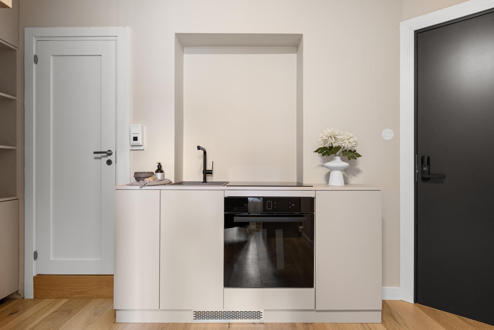 Praktisk utformet kjøkken utført i glatte fronter med moderne fargevalg - Overskap kommer Galleribilde