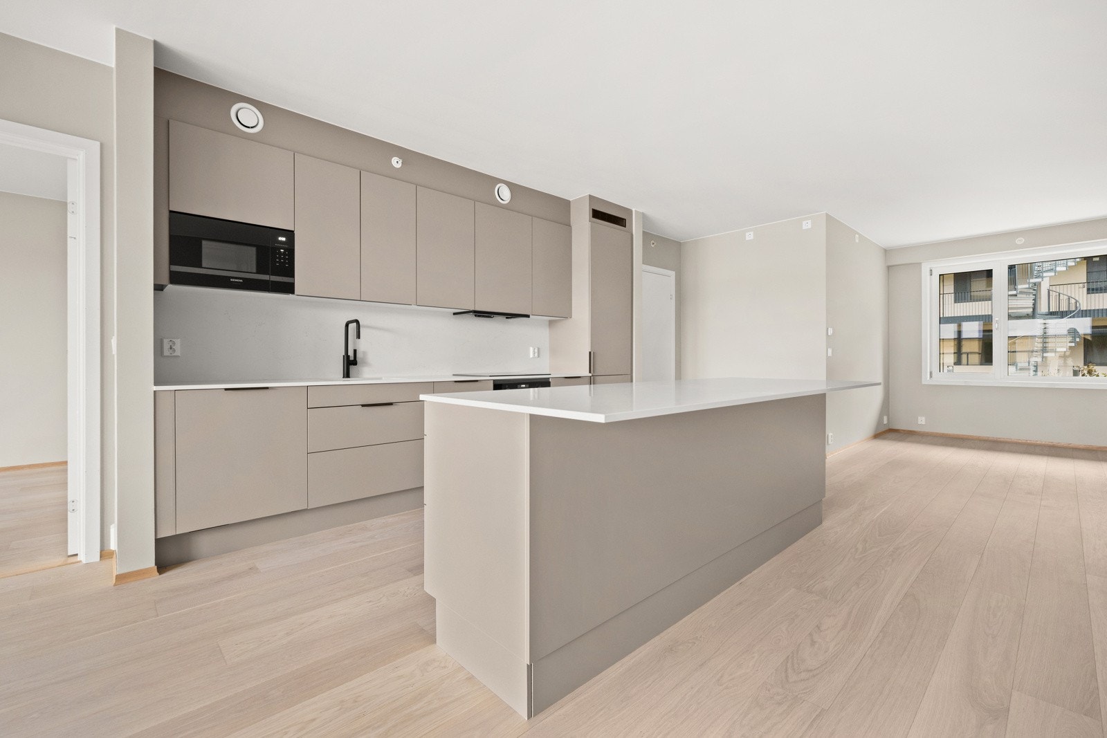 Åpent mot stuen er det etablert et moderne HTH-kjøkken som sklir sømløst inn i helheten. Galleribilde