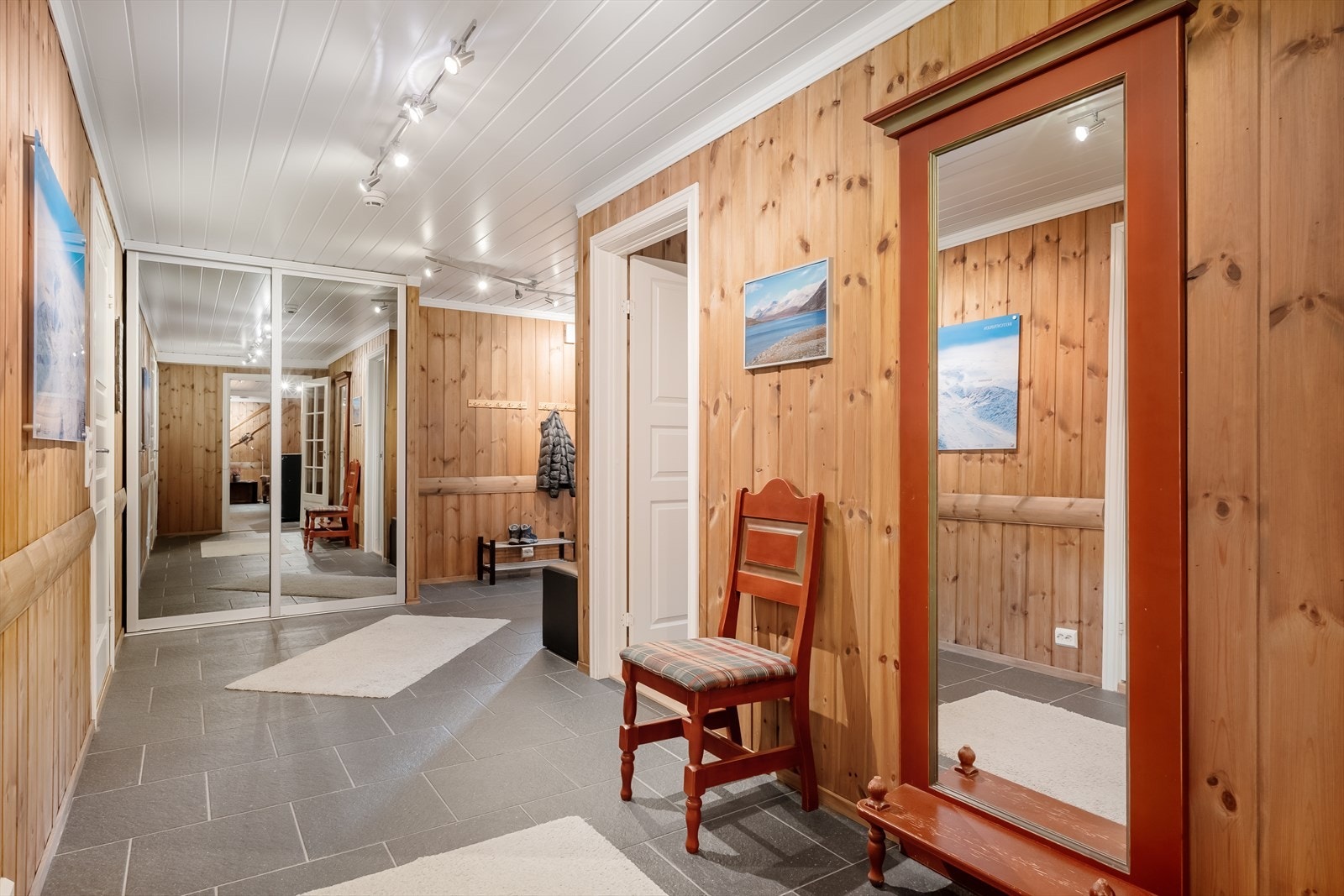 Gang med praktiske fliser på gulvet, og plass for yttertøyet i skyvedørsgarderobe og ellers. Galleribilde