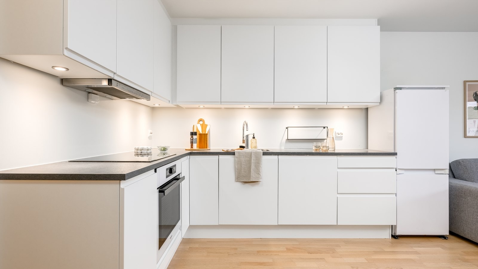 Innredningen har hvite, glatte fronter, laminert benkeplate og nedfelt oppvaskkum av stål. Galleribilde