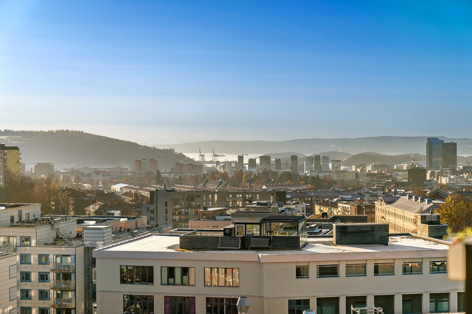 Bygget ligger på en høyde og leiligheten har hyggelig utsikt over hustakene og til fjorden. Galleribilde