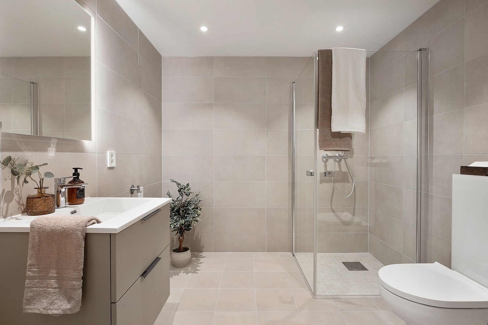 Delikat flislagt bad i lune og varme farger. Galleribilde