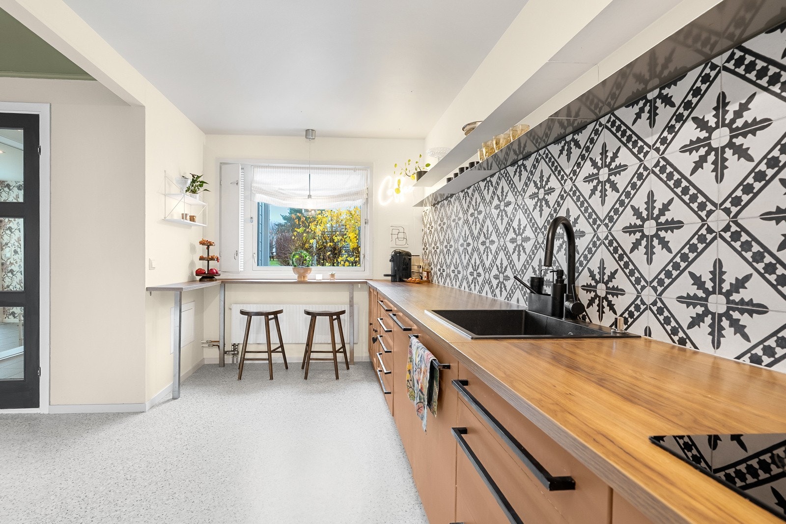 Videre er det vegghylle, flere vitrineskap og praktisk sitteplass ved vinduet. Galleribilde