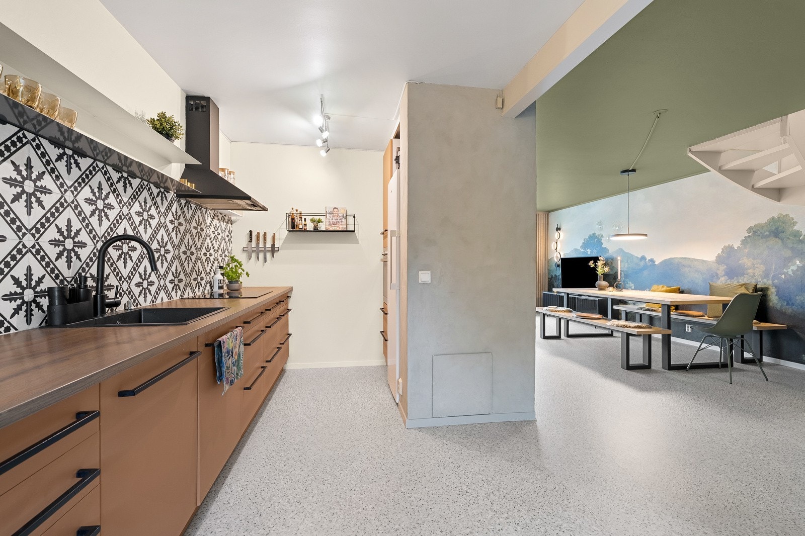 Flott kjøkken med glatte fronter og dekorative fliser på veggen. Galleribilde