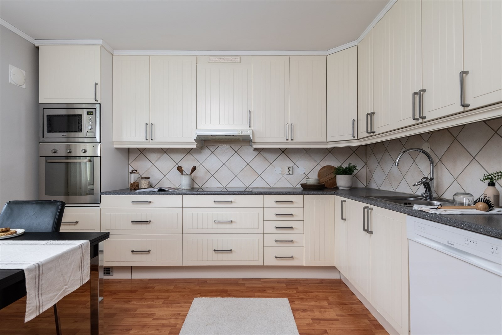 Romslig kjøkken med spiseplass integrerte hvitevarer Galleribilde