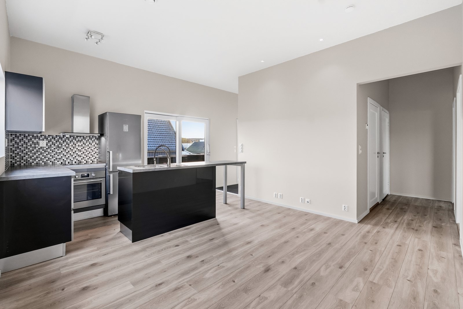 Rommet har en svært pen kjøkkeninnredning i italiensk design med grå høyglans fronter, fliser over laminert benk og kjøkkenøy med stålkum med ett-greps blandebatteri. Galleribilde