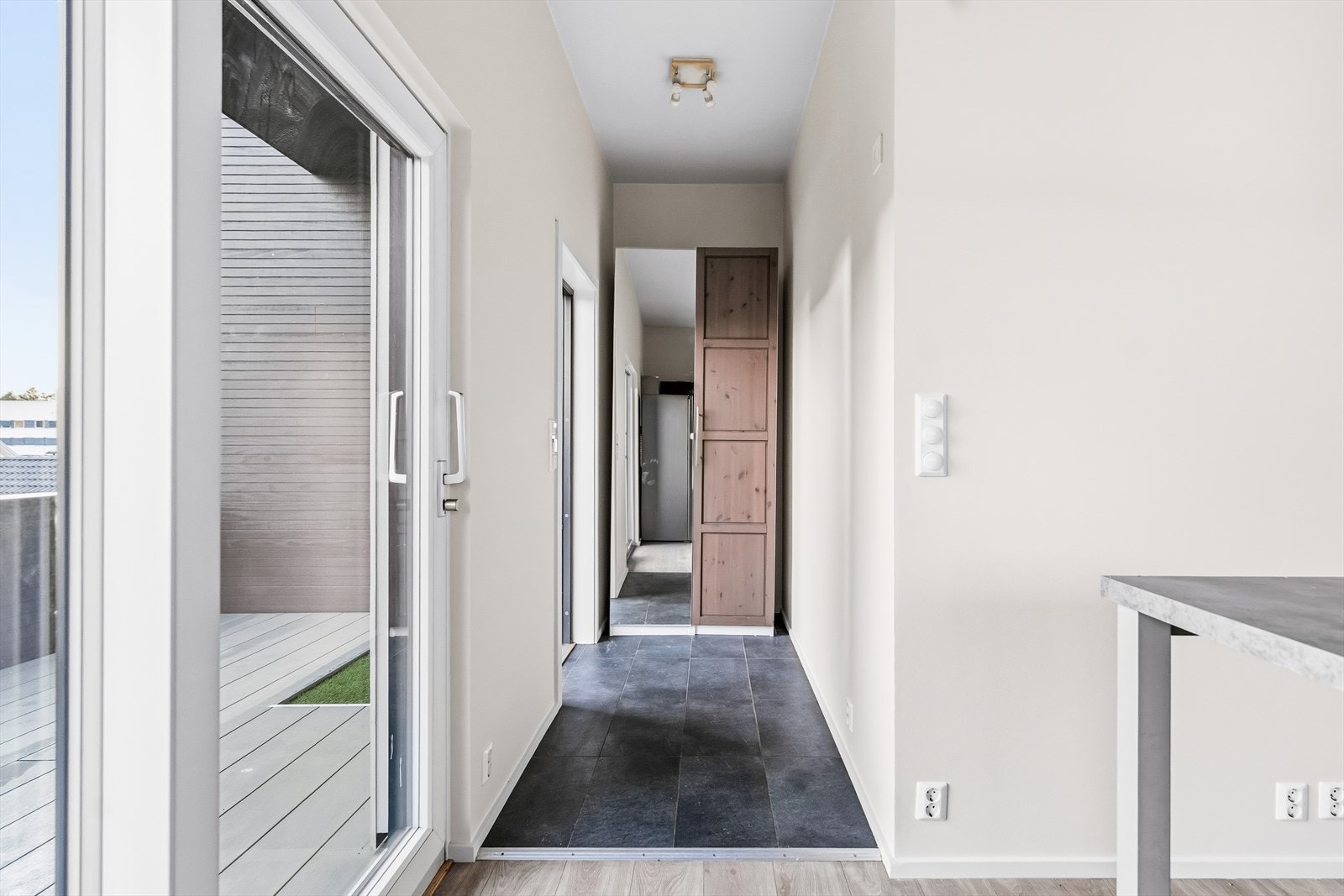 Vel inne i entréen er det plass til å henge fra seg yttertøy. Det er fliser på gulvet. Galleribilde