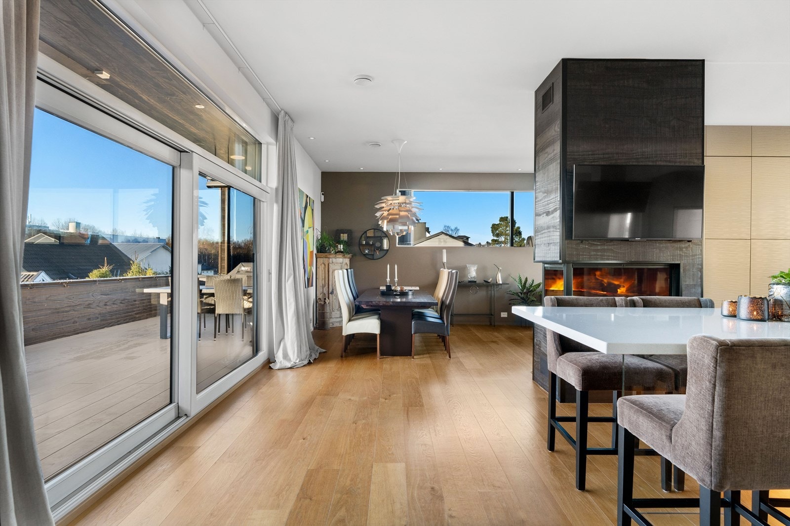 Stue og kjøkken ligger i en praktisk, sosial og halvåpen løsning, naturlig skilt med lekker peisovn. Det er utgang via store skyvedører til en herlig vestvendt terrasse. Galleribilde