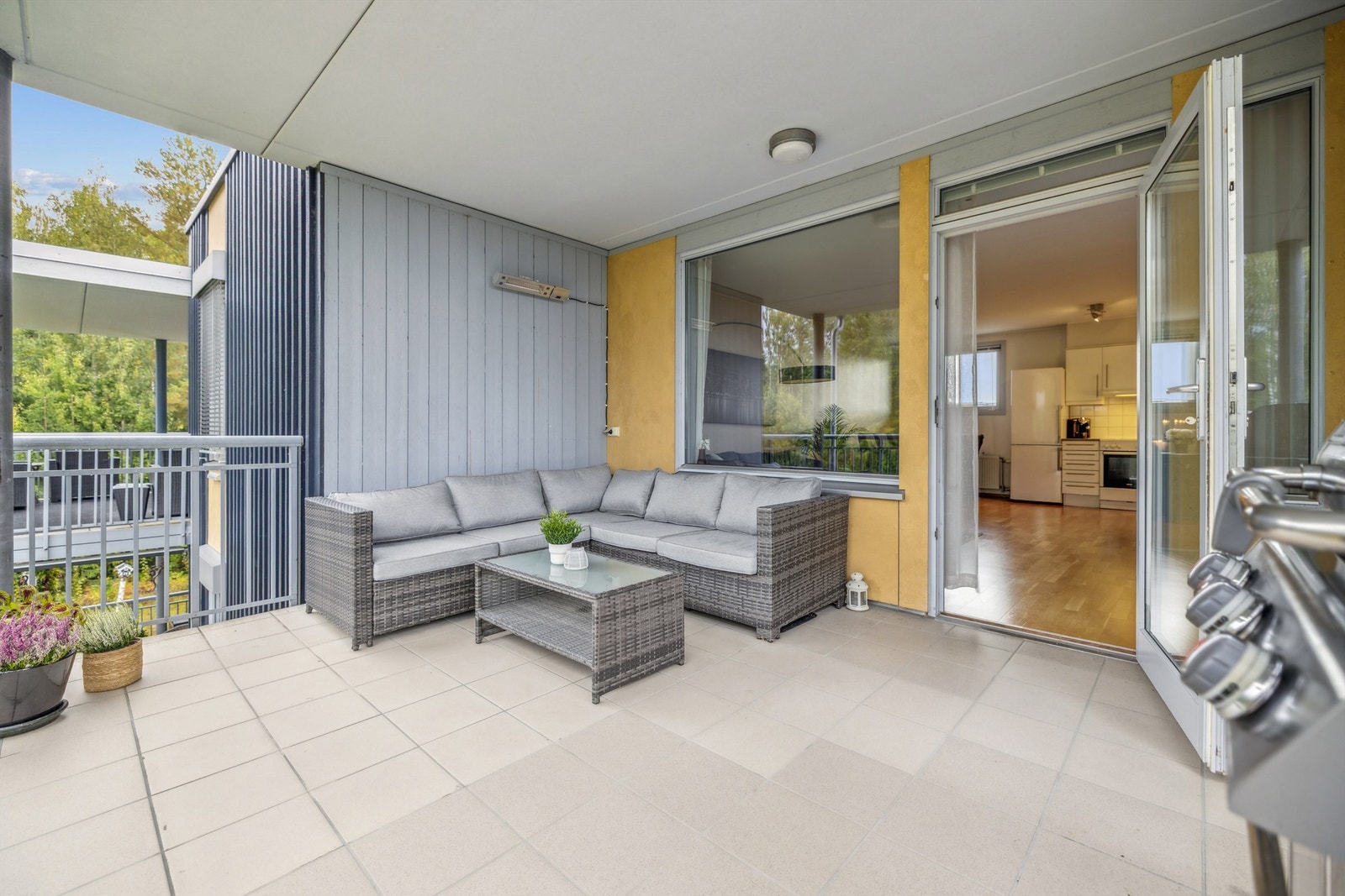 Balkongen fungerer som et flott, utvidet oppholdsrom i sommerhalvåret, med flislagt gulv og takoverbygg. Galleribilde