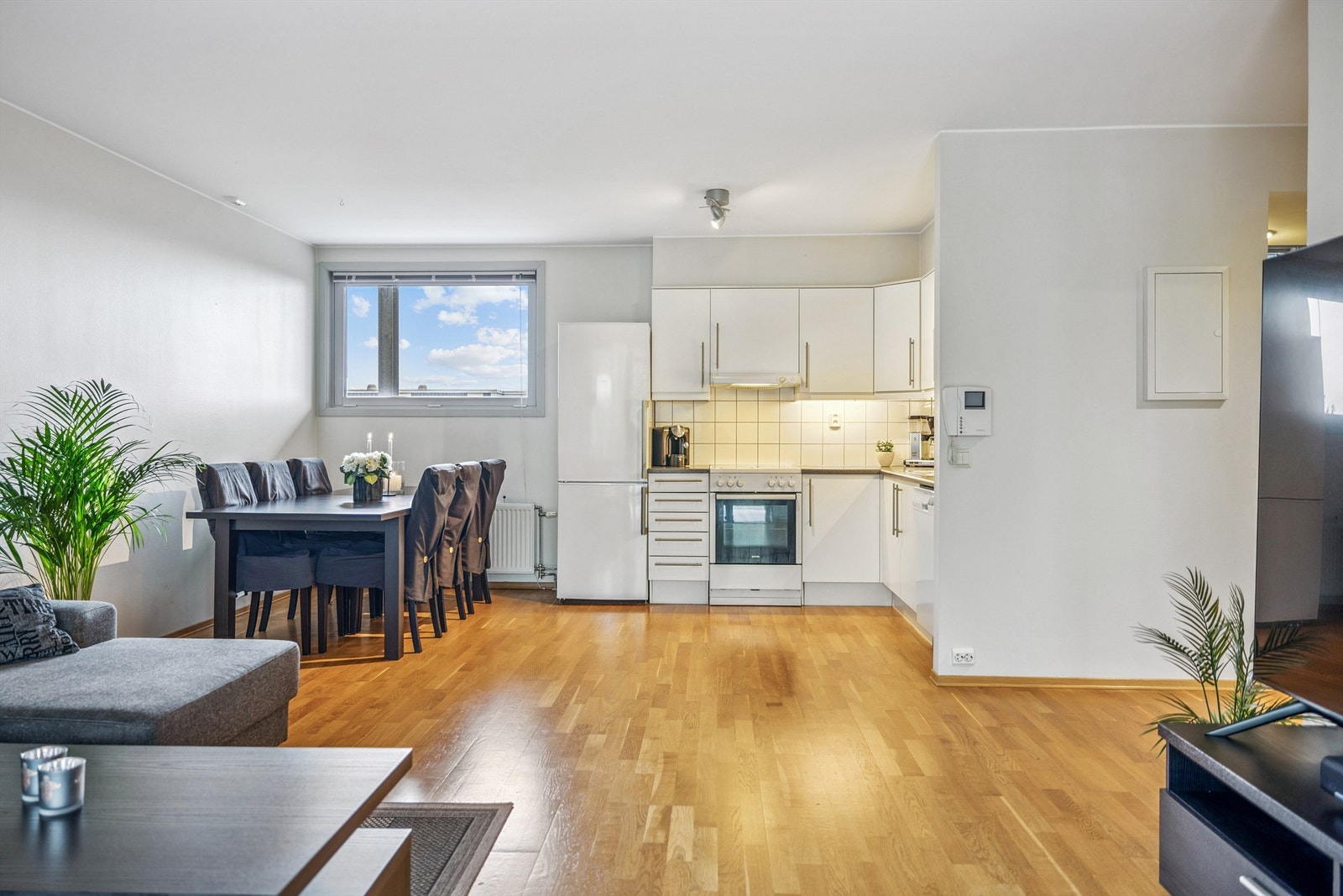 Kjøkkenet er praktisk innredet med glatte fronter, laminatbenkeplate og fliser over benken. Galleribilde