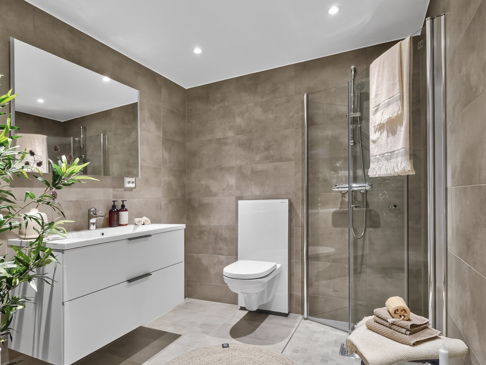 Romslig bad med moderne flis og opplegg for vaskesøyle Galleribilde