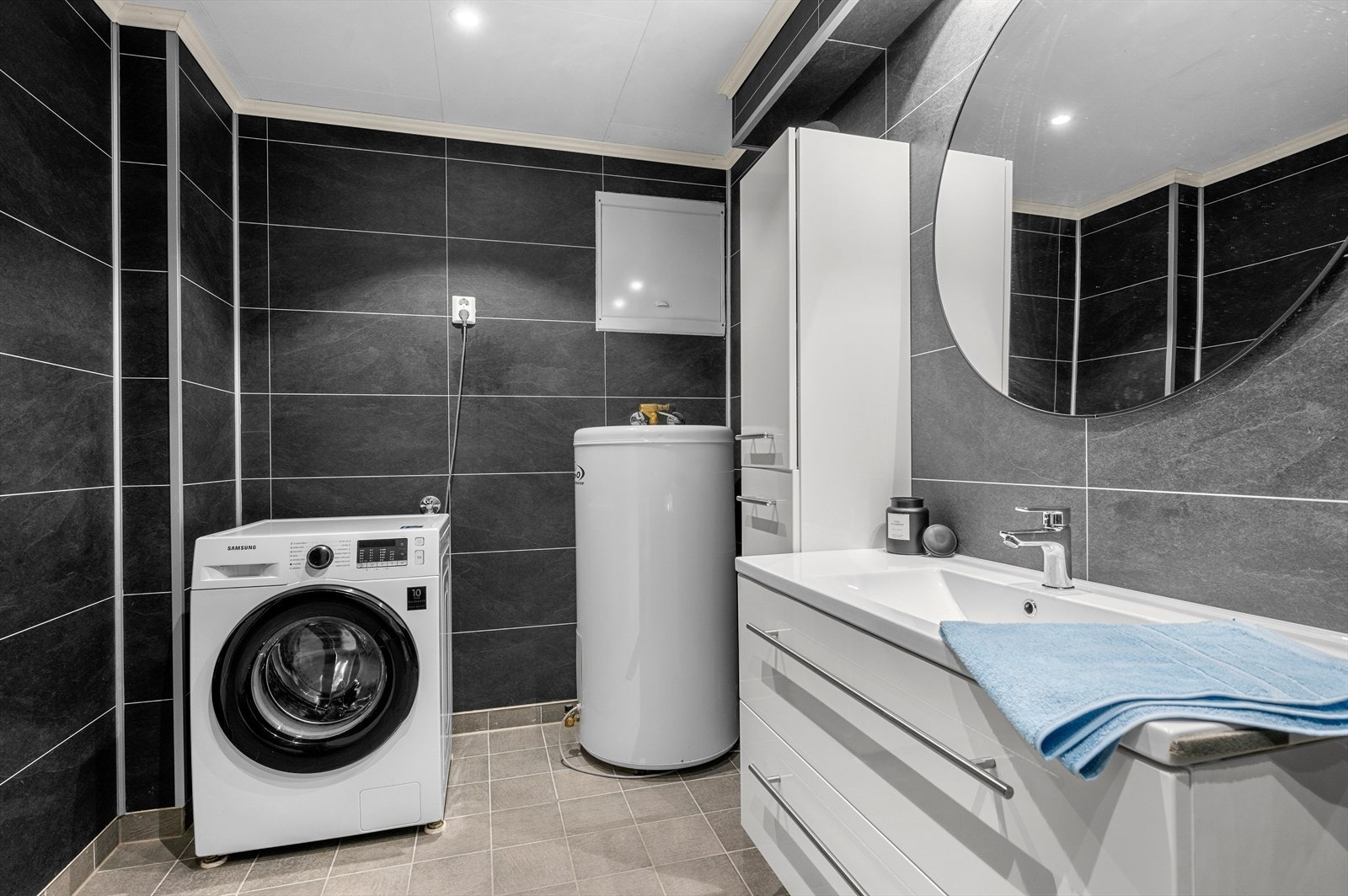 Flislagt gulv og praktisk opplegg for vaskemaskin på badet Galleribilde