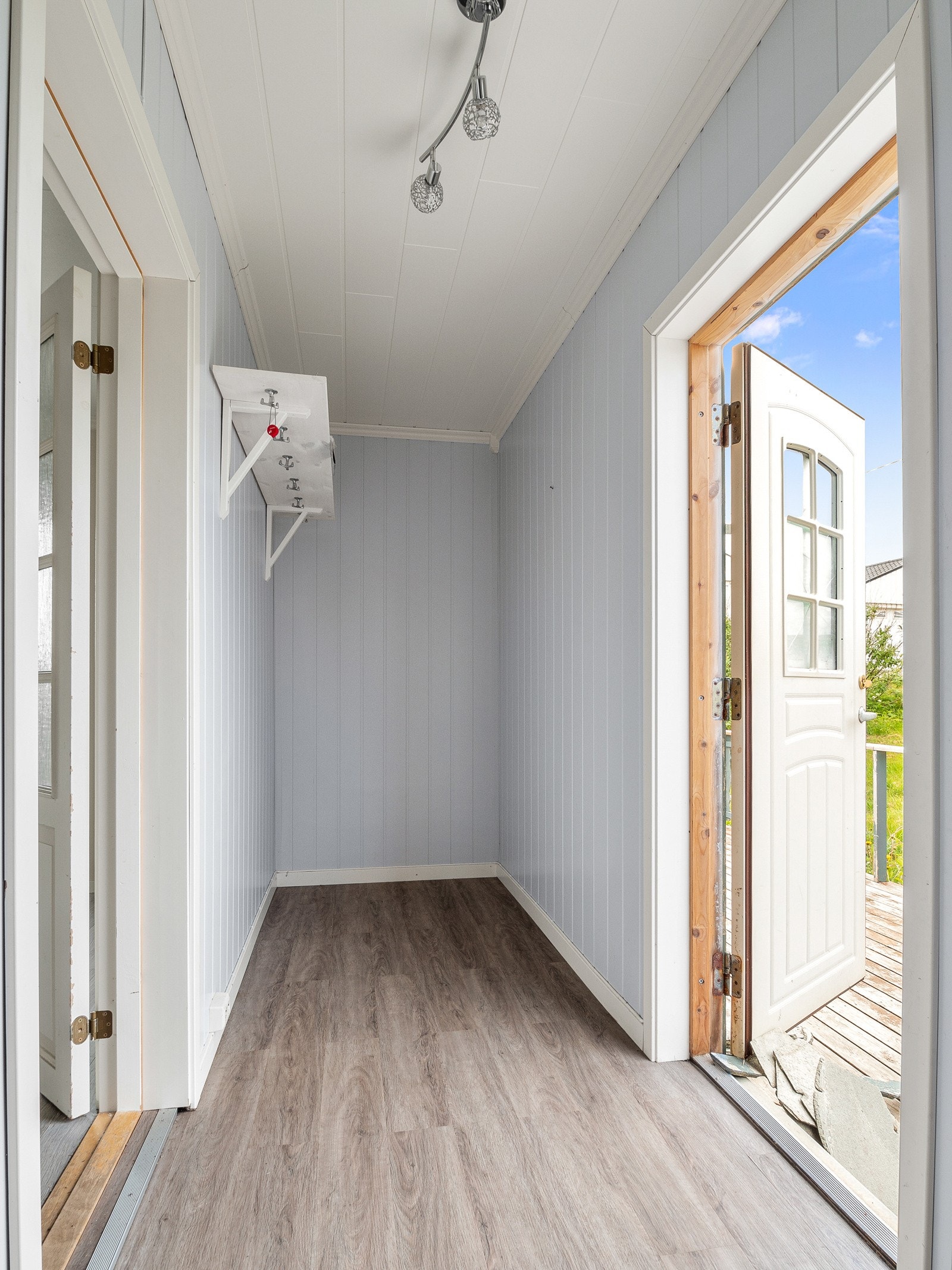 Man kommer inn i et romslig vindfang med god plass til å henge fra seg klær og utstyr Galleribilde