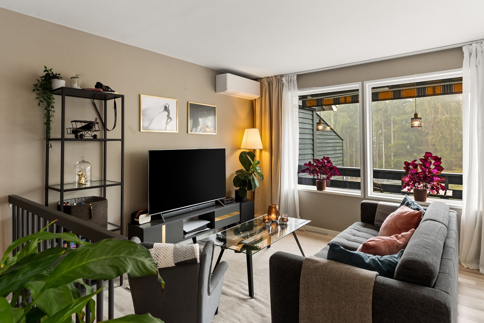 Stua er romslig med tidsriktige farge- og materialvalg på både gulv og vegger - Vinduene gir godt med naturlig lysinnslipp. Galleribilde