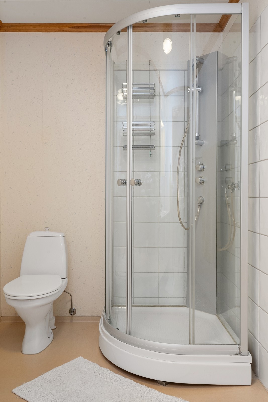 Badet er innredet med gulvmontert toalett og dusjkabinett Galleribilde