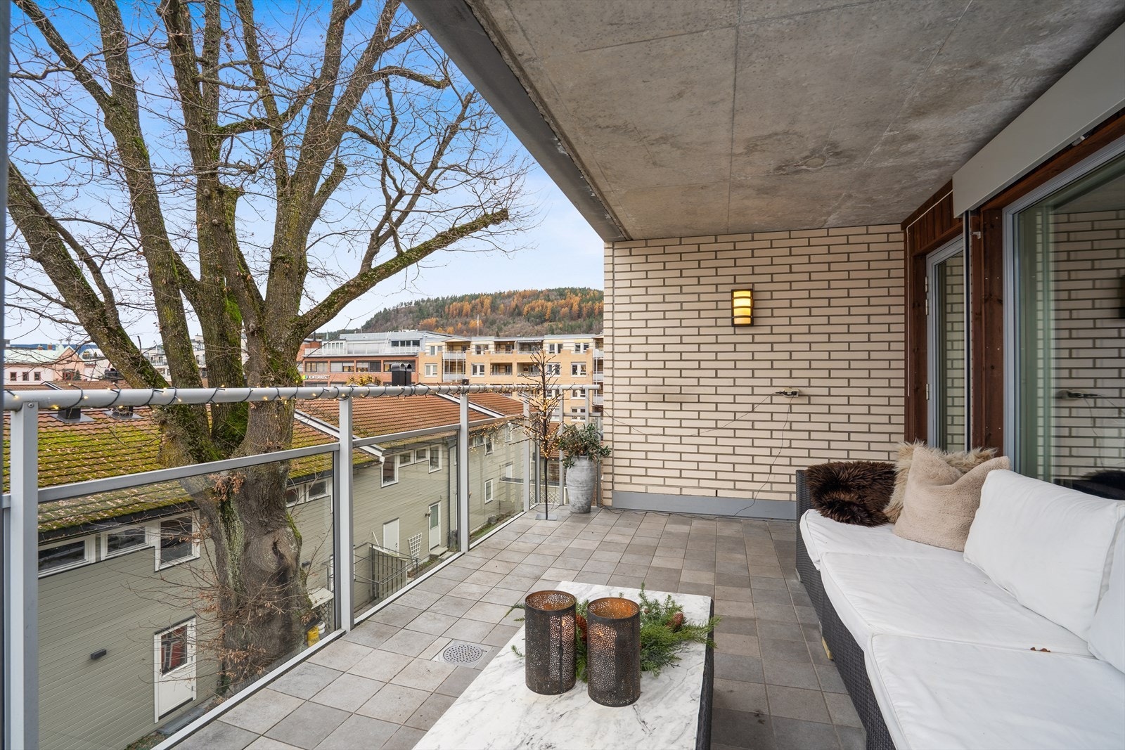 Takoverbygd balkong i betongkonstruksjon med glassrekkverk gir et trygt uteområde. Galleribilde