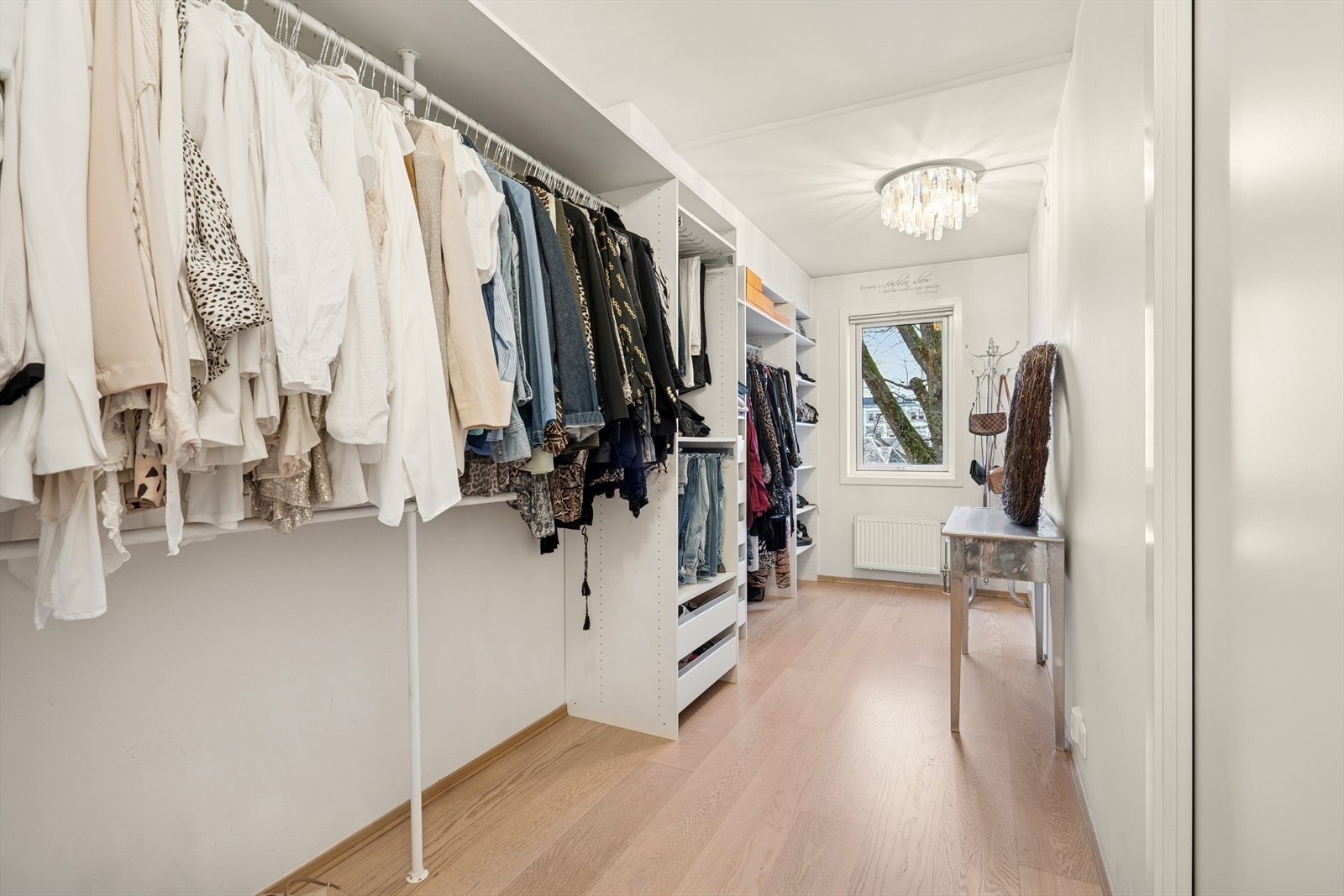 Garderobeløsning med skyvedører gir effektiv oppbevaring i omkledningsrommet. Malte vegger og parkettgulv gir et ryddig inntrykk i rommet. Dette er opprinnelig et soverom. Galleribilde