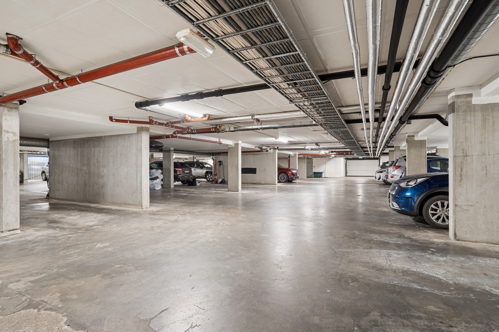 Det er en parkeringsplass med elbillader i felles parkeringskjeller. Galleribilde