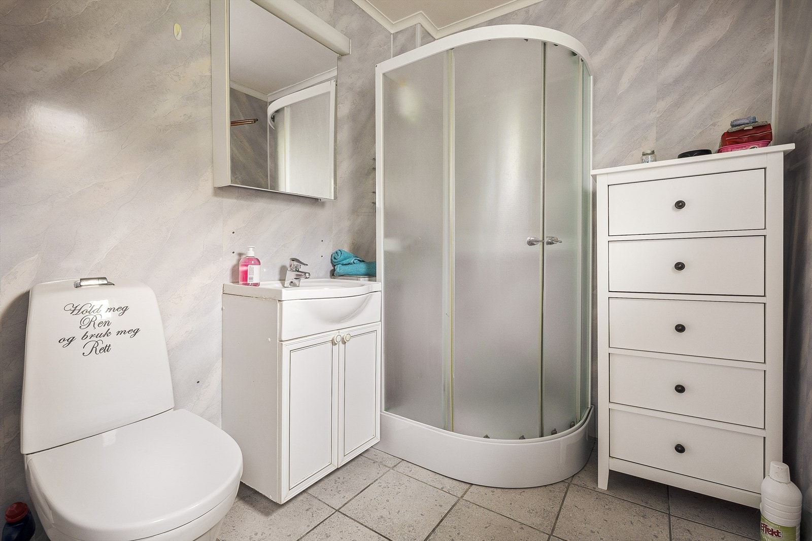 Badet er innredet med servant i møbel, toalett og dusjkabinett. Galleribilde