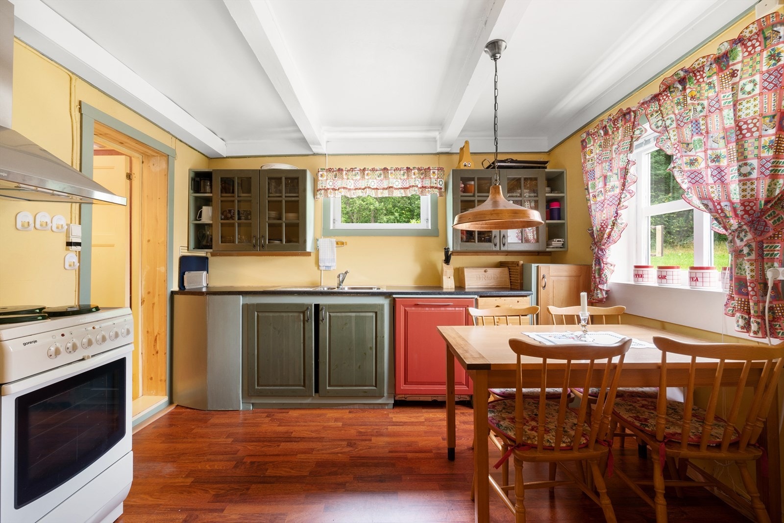 Kjøkkenet har eldre, profilert innredning og integrert oppvaskmaskin. Galleribilde