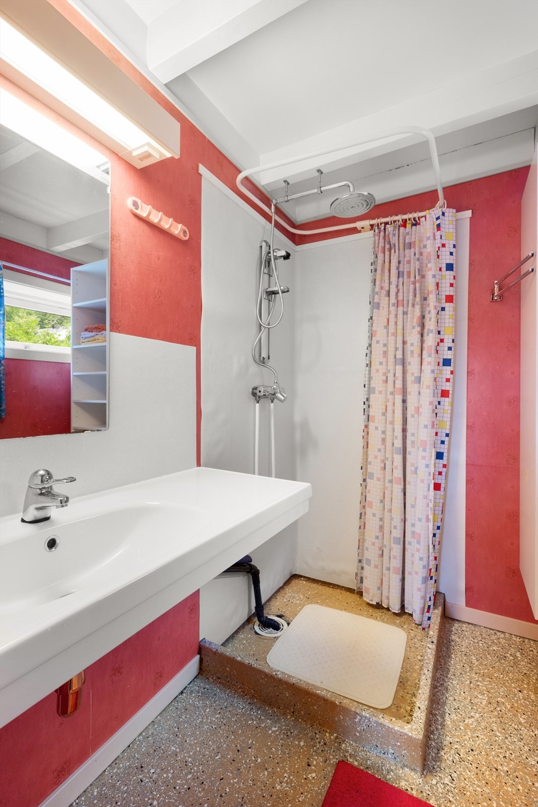 Badet har toalett, dusjhjørne med regnfallsdusj og veggmontert toalett. Galleribilde