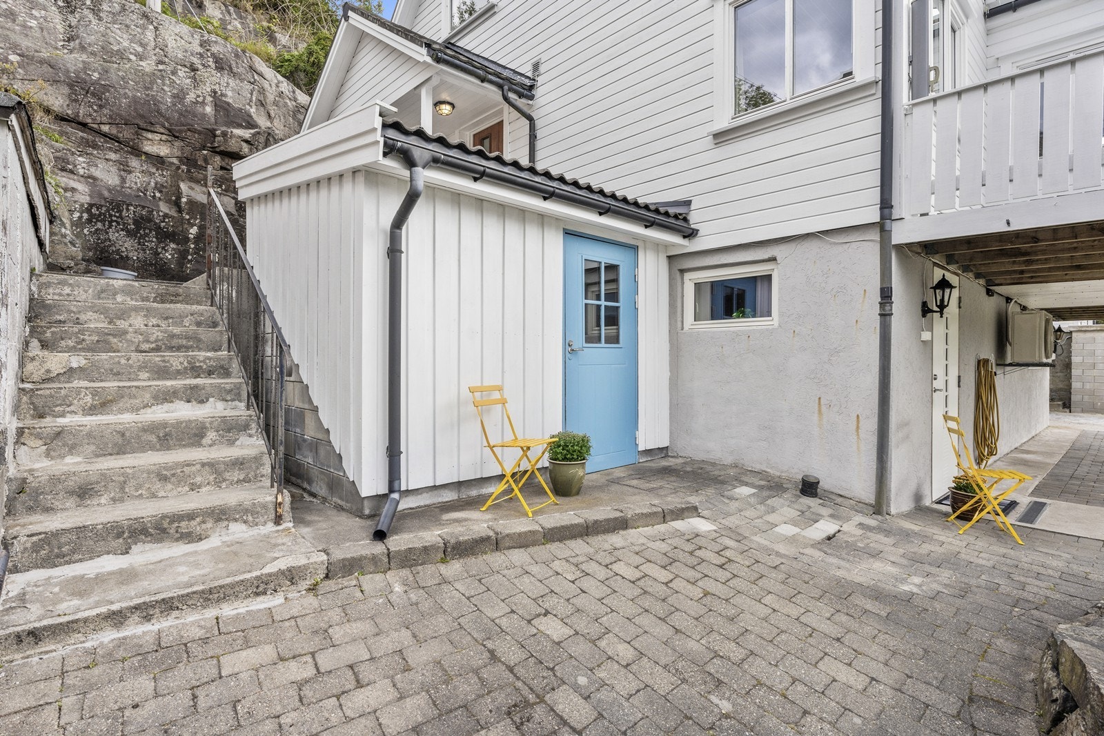 Her er inngang til utvendig bod, hvit dør under veranda er inngang til kjelleretasjen Galleribilde