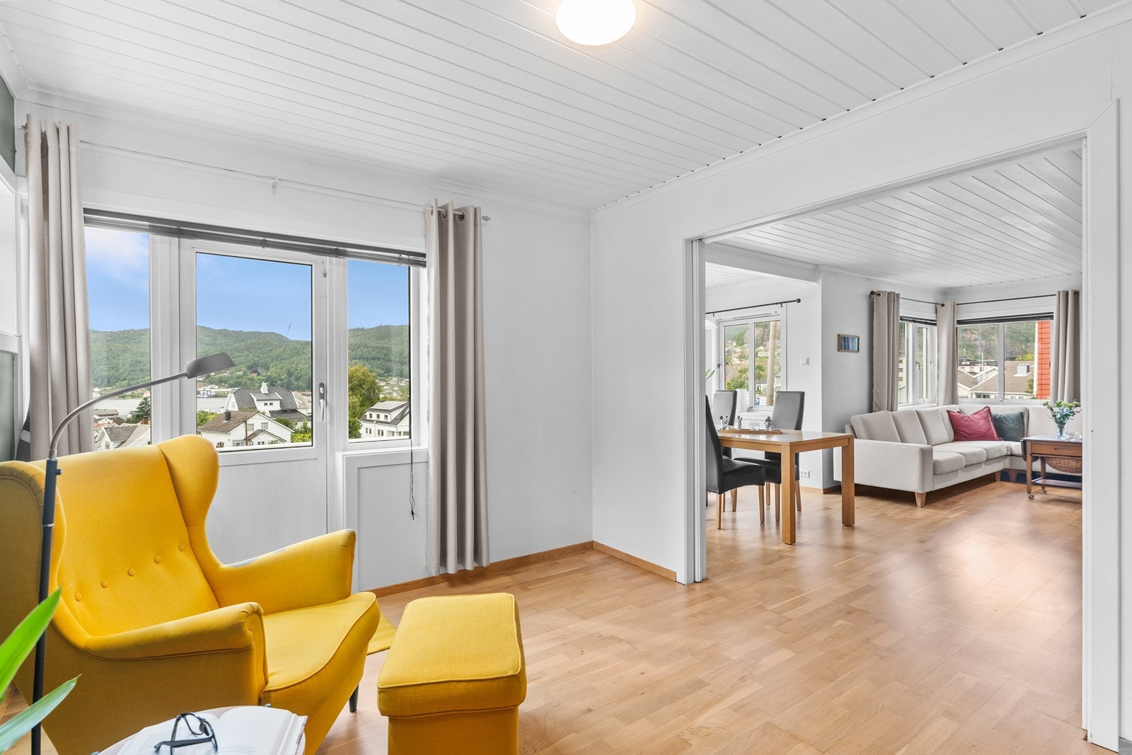 Det er åpent fra stua inn mot kjøkken. Her er utgang til stor veranda som omkranser boligen. Galleribilde