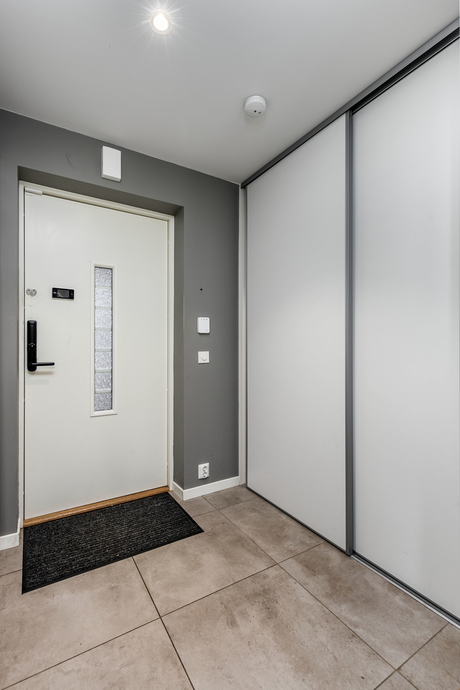 Innbydende entrè med fliser og vannbåren gulvvarme. Det er montert praktisk skyvedør i entréen. Galleribilde