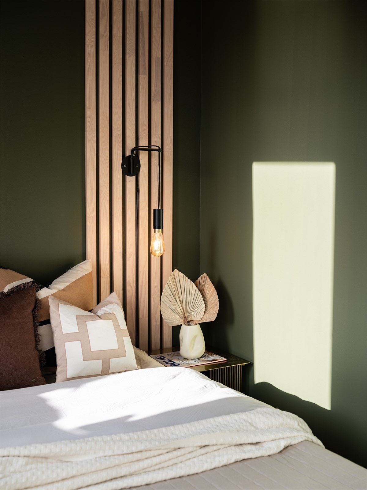 Vegger og tak er malt i en varm grønnfarge og har integrerte eikespiler med belysning som fungerer som nattbordlys. Galleribilde