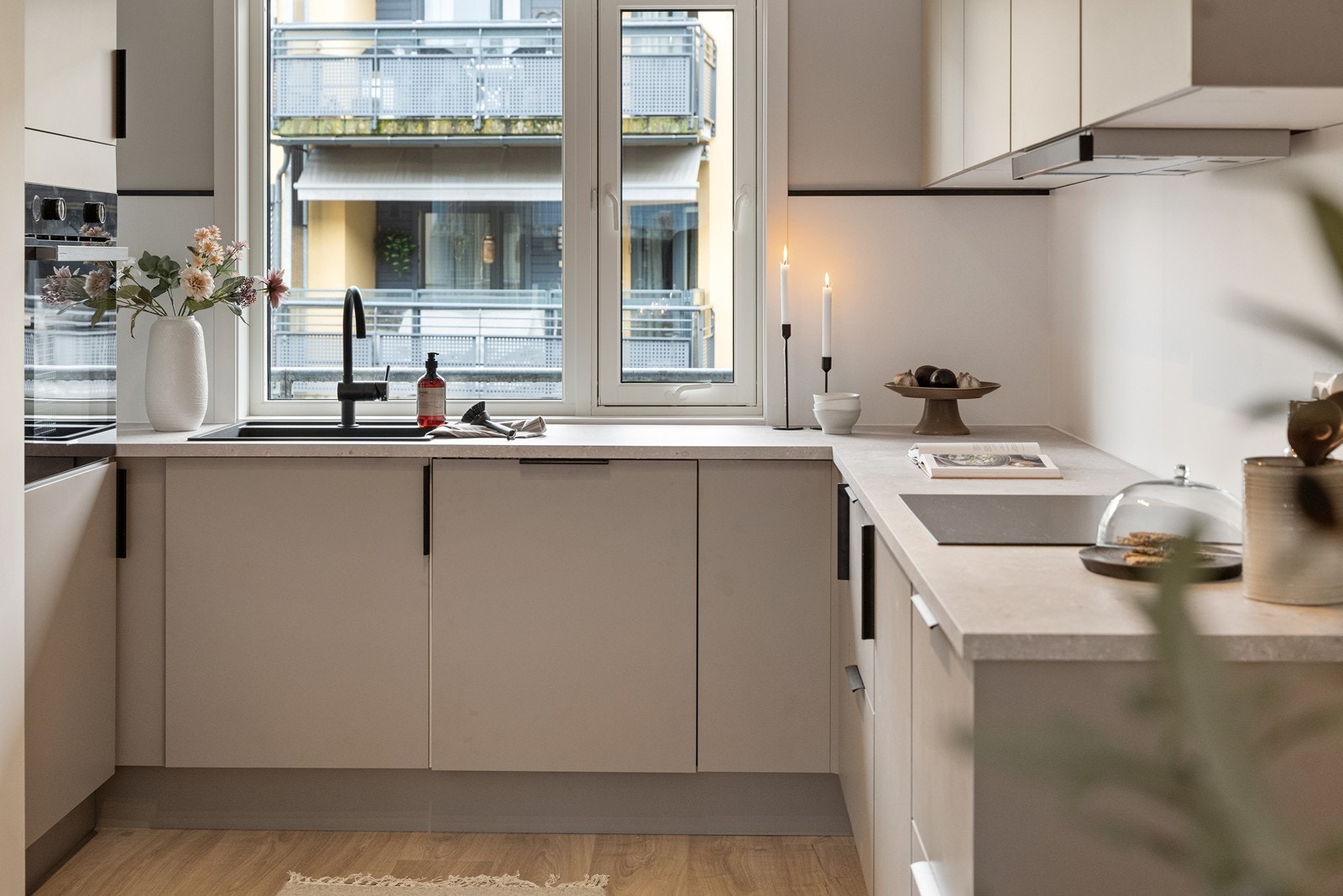 Lekkert HTH kjøkken fra 2025. Kjøkkenet har slette fronter og laminat benkeplate. Integrert komfyr, platetopp, kjøl/fryseskap og oppvaskmaskin. Det er utsyn mot hyggelig bakgårdsrom/atrium fra kjøkkenvindu. Galleribilde