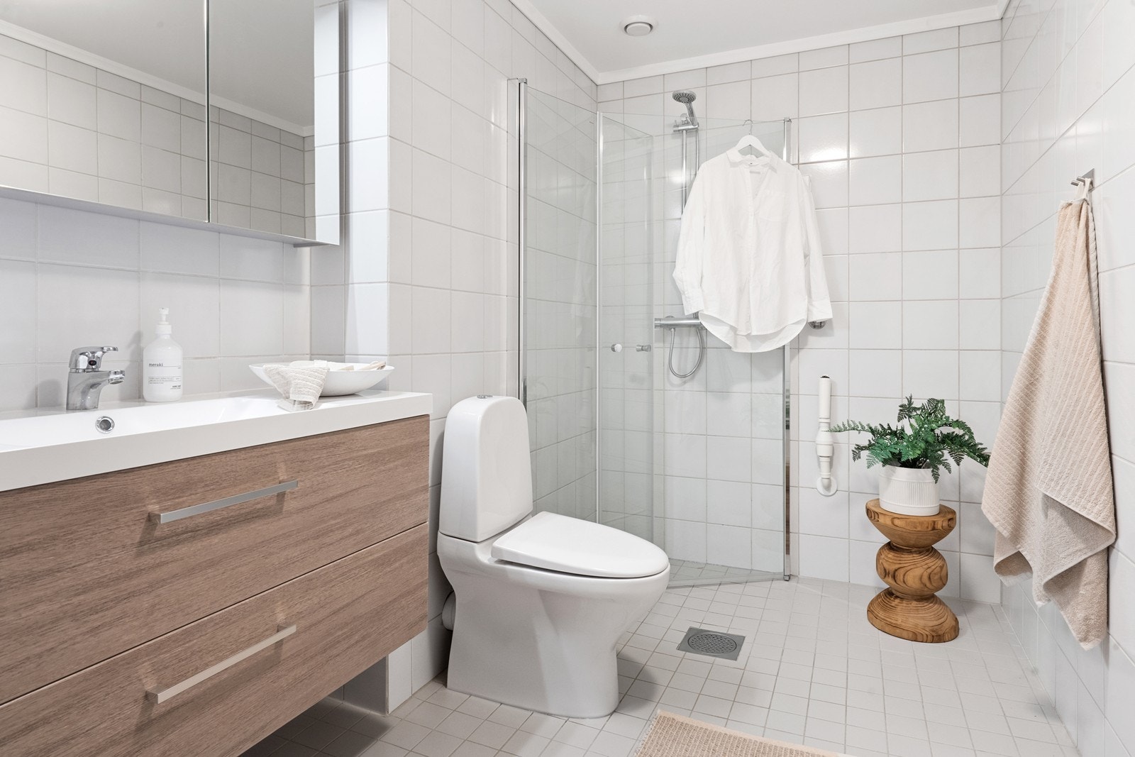 Bad/vaskerom fra byggeår. Rommet har ny innredning med nedfelt servant, gulvfestet toalett, dusjhjørne og opplegg for vaskemaskin. Galleribilde