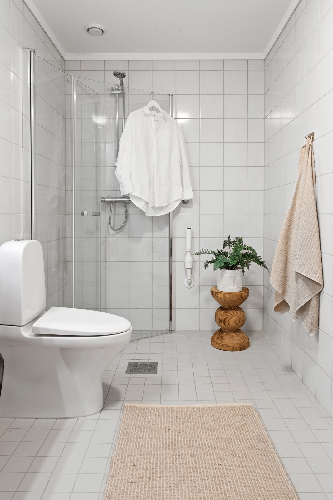 Det er gråtonede fliser på gulv og hvite fliser på vegg. Galleribilde