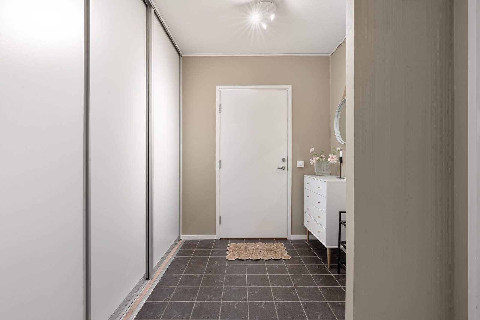 Entré med god plass til lagring av yttertøy i skyvedørsgarderobe.