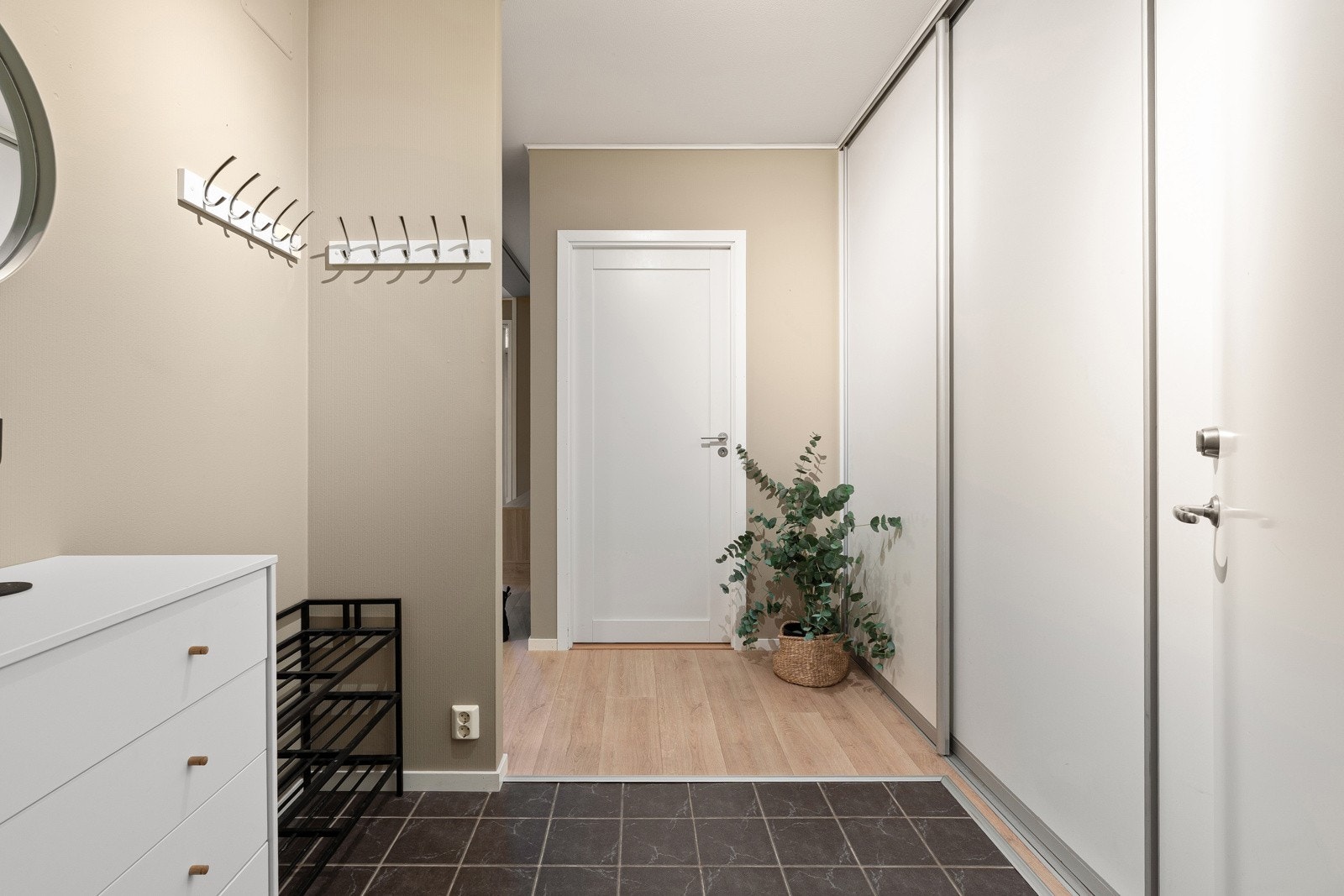 Romslig entré med  fliser på gulv, skyedørsgarderobe og ellers god plass til ekstra skap, kommode eller skoskap.