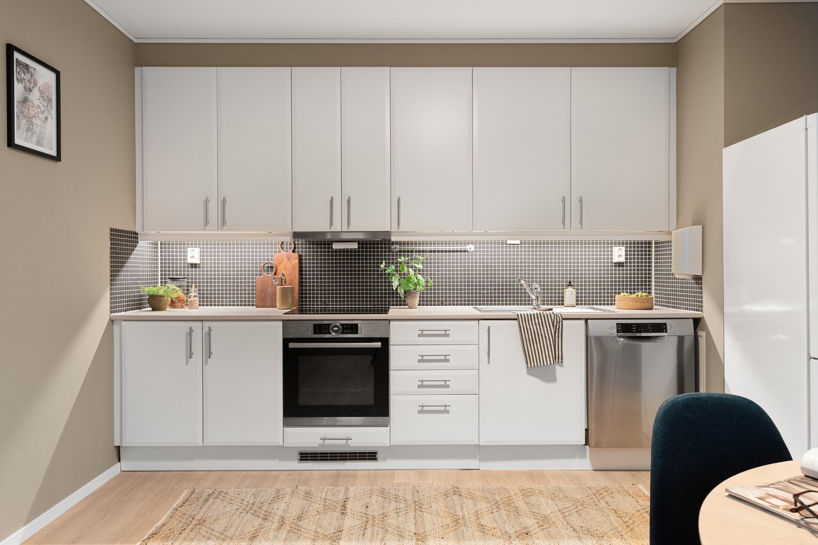 Tidløst kjøkken med rikelig med skap- og benkeplass i over- og underskap. Integrert stekeovn og platetopp!