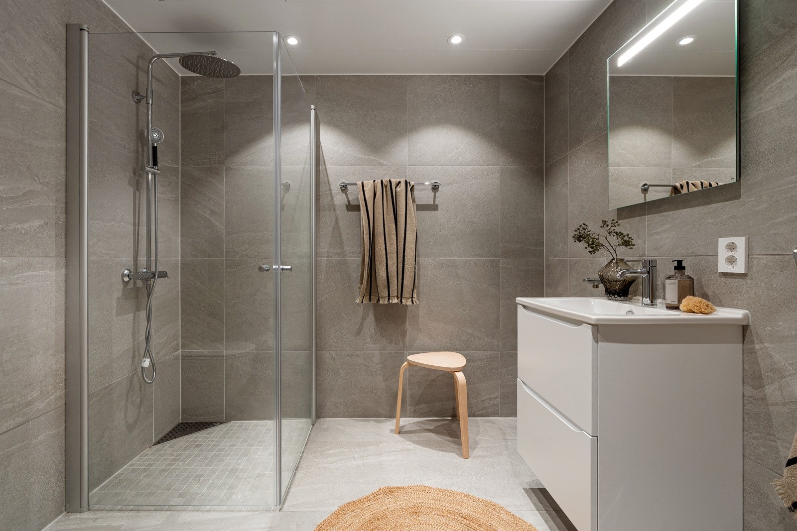 Delikat bad med 60x60 flis, dusjhjørne med innfellbare dusjvegger og downlights i himling.