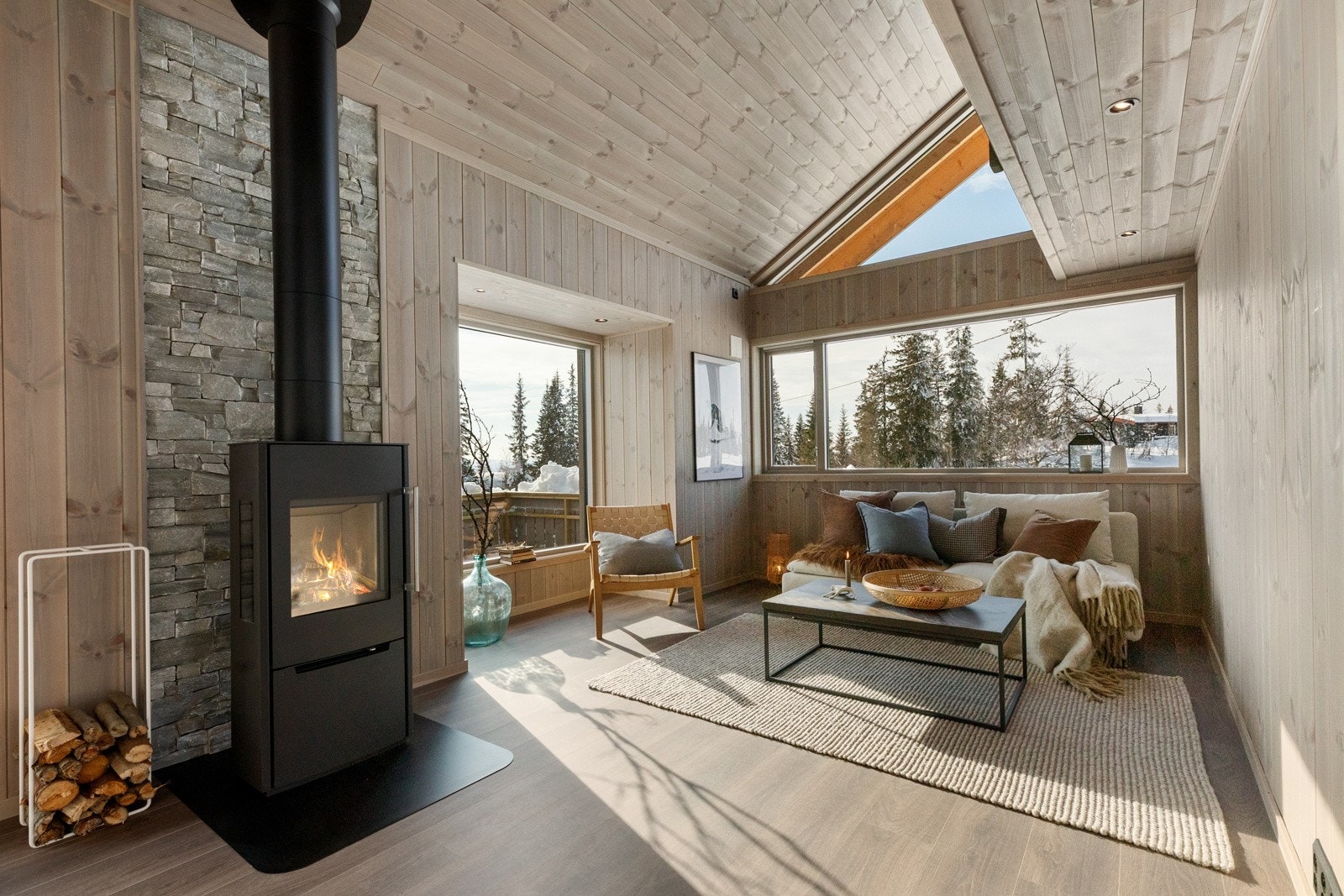 Flott peisovn plassert midt i rommet gir en god varme og hyggelig atmosfære Galleribilde