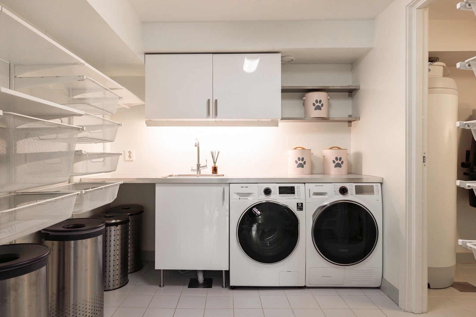 Vaskerommet har inngang fra trappehallen, innredet med en vaskekum nedsenket i en laminatbenkeplate, overskap, benkeskap, et praktisk hyllesystem, samt opplegg for vaskemaskin og tørketrommel i nisje under benken. Det er skyvedør inn til teknisk rom. Galleribilde