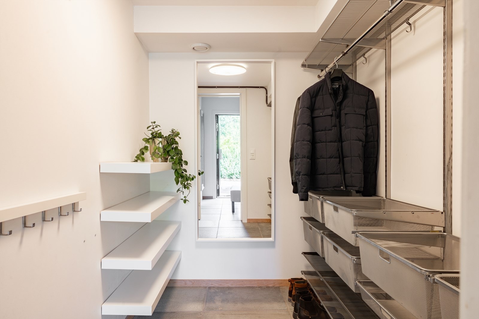 Boligen har godt med oppbevaringsplass i garderoberom tilknyttet entreen, samt lagringsplass i en stor bod ved garasjen. Rommet har et praktisk hyllesystem med både skohyller, knagger og trådkurver. Galleribilde