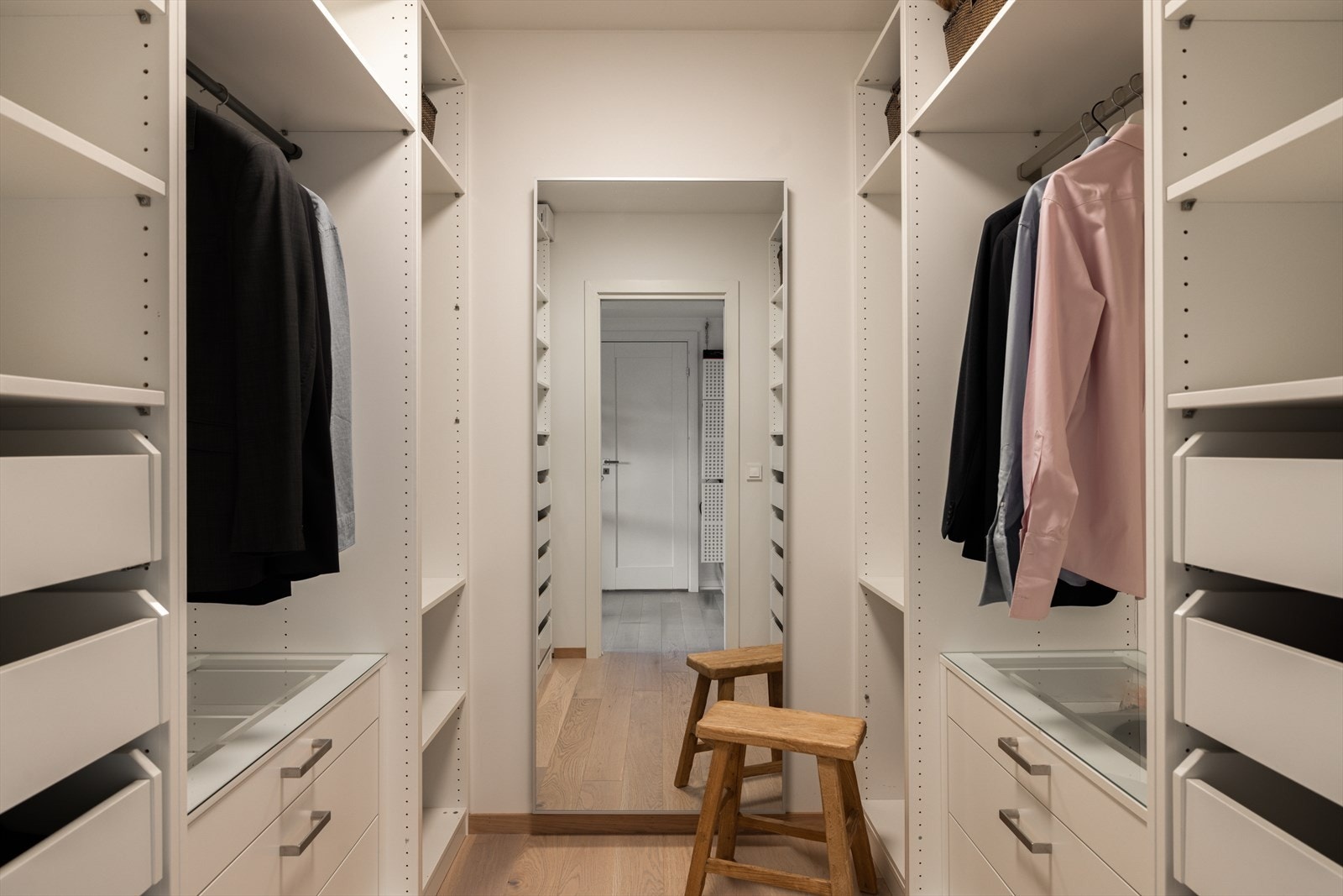 Walk-in closet er utstyrt med åpne skapinnredninger langs to sider, med skuffer, hyller og garderobestenger. Galleribilde