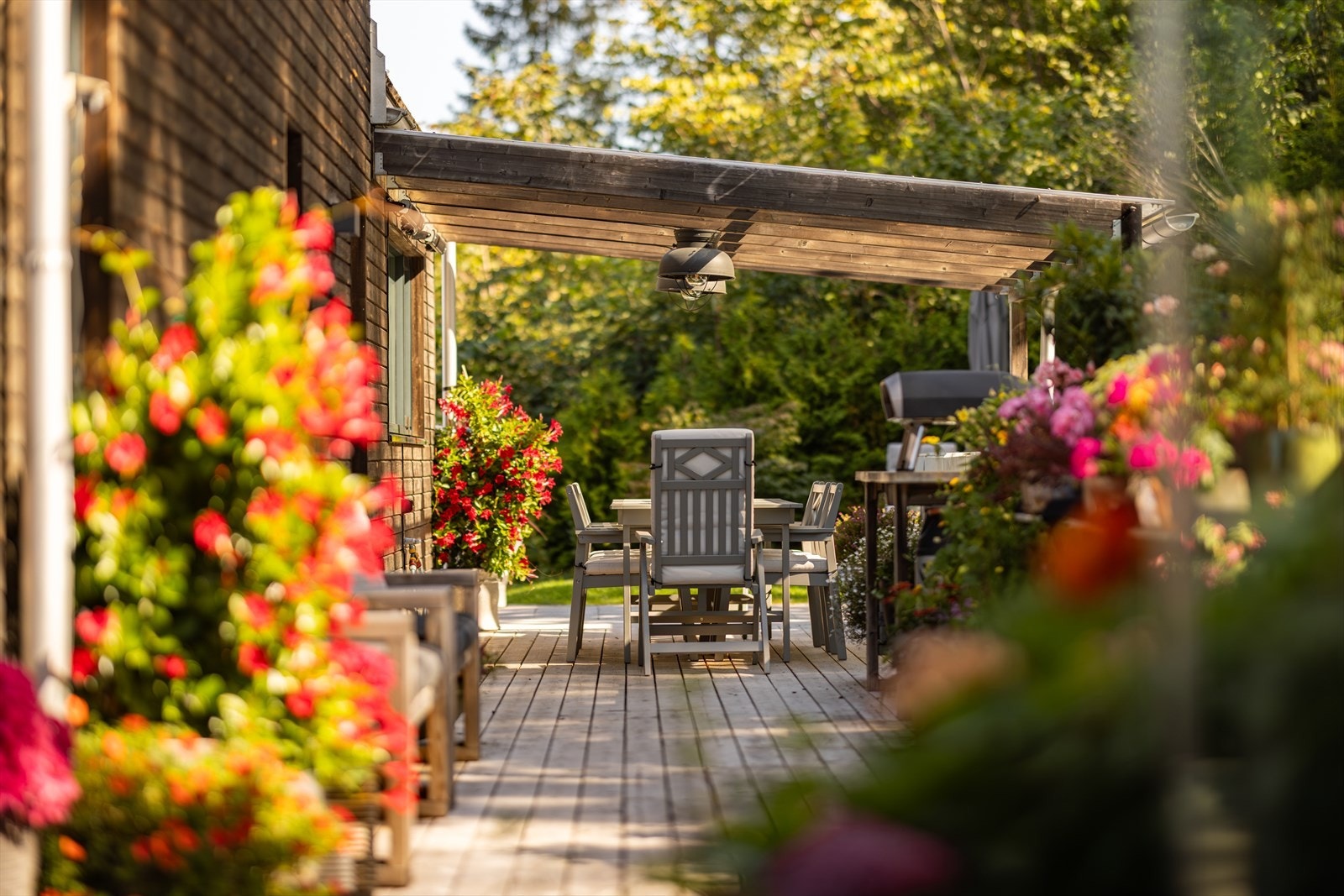 Terrassen fortsetter sømløst og inkluderer et utekjøkken med vaskekum og støpt benk på 36,4 kvm. Galleribilde