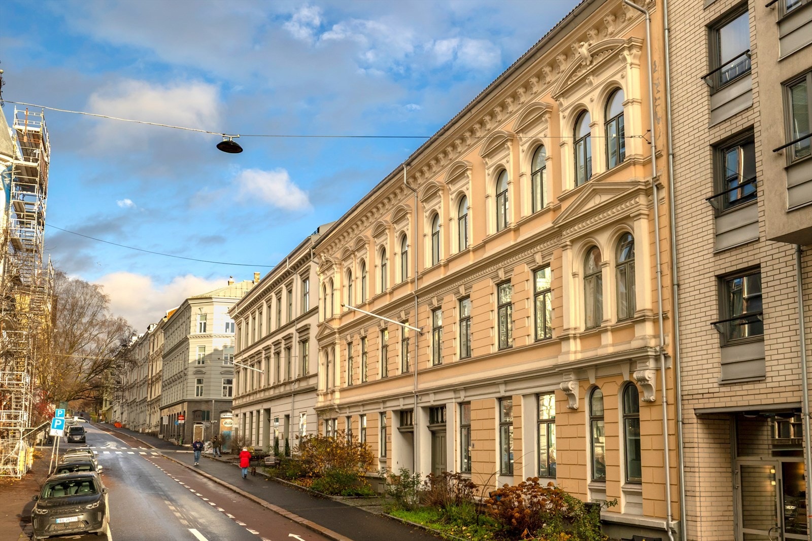 Ærverdig bygård med klassiske detaljer og forhager langs fortauet Galleribilde