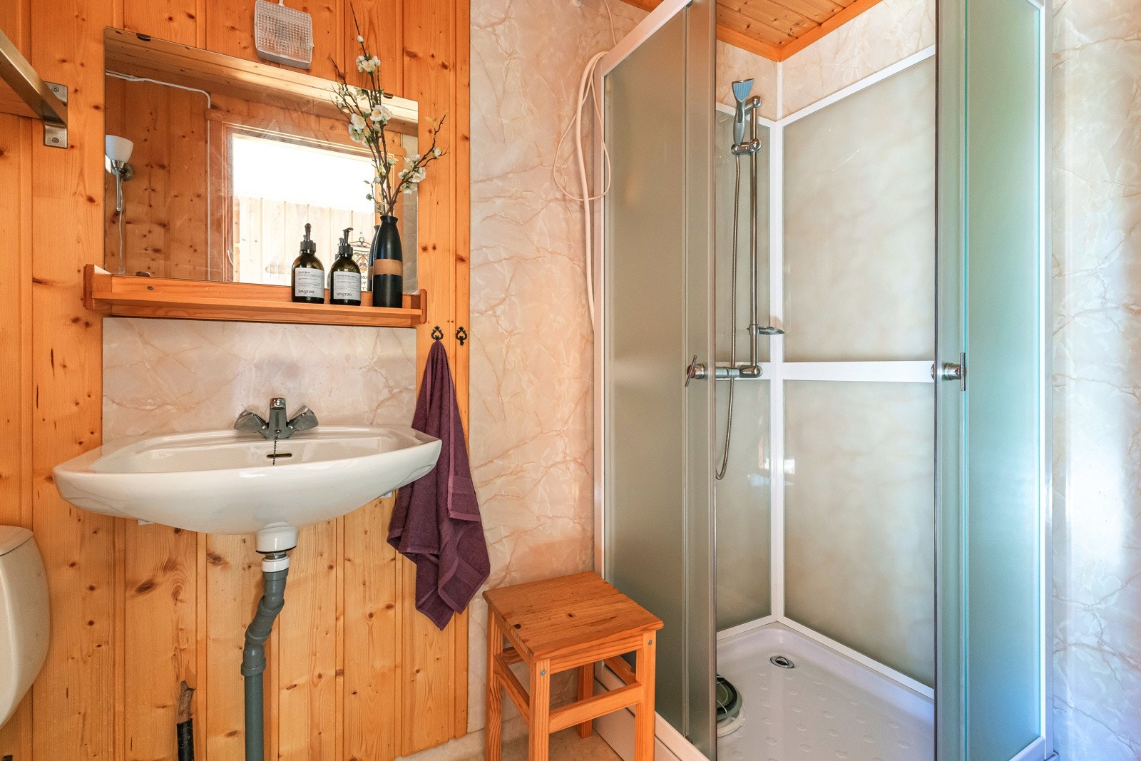 Enklere hyttebad med servant, dusjkabinett og toalett Galleribilde